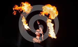 Sexy girl artist twirl burning batons during sparkling fire performance in darkness, lighting photo