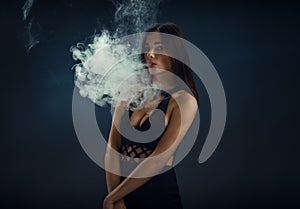 girl in a black dress smoking electronic cigarette