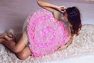 girl with blond hair posing with heart, symbol of Valentine's day