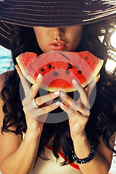girl with dark hair eating watermelon