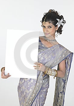 girl in fancy sari holding white board