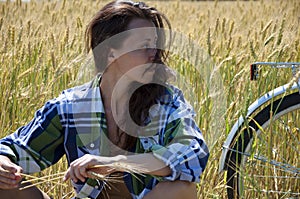 Sexy girl looking away while relaxing in wheat field. woman relax after riding bicycle. bike trip in rye field. have a little