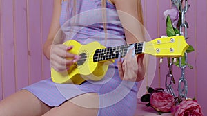 Sexy girl sit on swing with ukulele