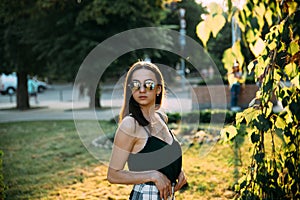 Sexy girl in a T-shirt in an evening park in mini shorts photo