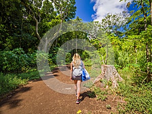 Sexy girl walks into the tropical forest of Honolua Bay in Maui Hawaii