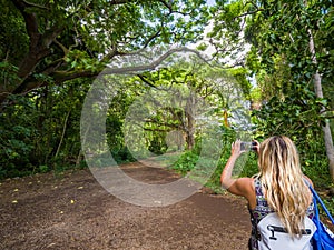 Sexy girl walks into the tropical forest of Honolua Bay in Maui Hawaii