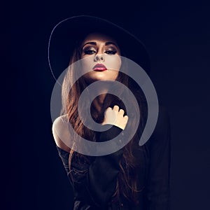 glamour female model posing in black shirt and elegant hat