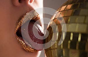 Sexy golden lips makeup. Seductive fashion gold metal lip. Beautiful make-up.