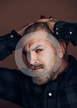 Sexy gorgeous stylish man. Close-up face of young bearded man on dark background - professional studio light.