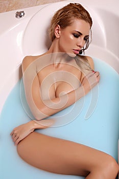 gorgeous woman with blond hair relaxing in bathroom