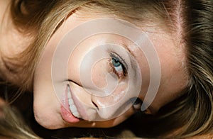 Sexy gorgeous woman with shadows on beautiful face on black studio. Blonde smiling girl closeup face. Sensual smile