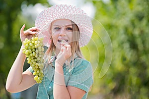 Sexy grape. A pretty sexy young woman holding a bunch of grape on her face. Young woman licking grapes of green grapes