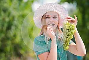 Sexy grape. A pretty sexy young woman holding a bunch of grape on her face. Young woman licking grapes of green grapes