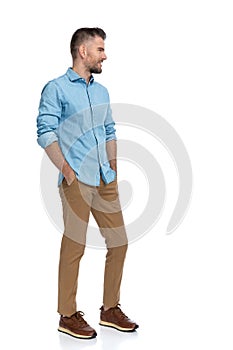 Sexy grizzled man holding hands in pockets and looking to side