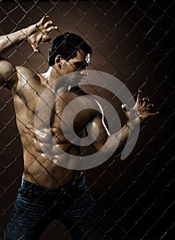 Il muscoloso, bel ragazzo sexy , su di compensazione in acciaio recinzione.