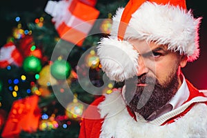 Sexy handsome bearded Santa. Christmas man with long beard in red santa claus hat and coat. Holiday for new year