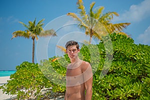 Sexy handsome male model at the beach at the tropical island luxury resort