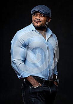 Sexy handsome male posing for camera. Athletic model in fashionable clothes looking away during the shooting in studio