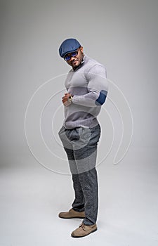 Sexy handsome male posing for camera. Athletic model in fashionable clothes in studio.