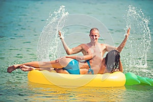 Sexy happy couple on Caribbean sea. Pineapple inflatable mattress, activity joy. Maldives or Miami beach water. Couple