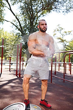 Sexy, hot muscular sportsman doing exercises in the park. A strong boy on a natural background. Sports concept.