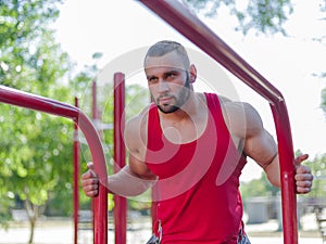 Sexy, hot muscular sportsman doing exercises in the park. A strong boy on a natural background. Sports concept.