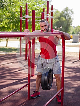 Sexy, hot muscular sportsman doing exercises in the park. A strong boy on a natural background. Sports concept.