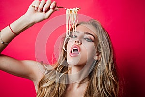 Sexy kitchen. Girl eat spaghetti. Woman italian cuisine eating pasta with her hands and mouth.