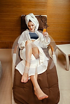 Sexy lady relaxing with cocktail in spa chair