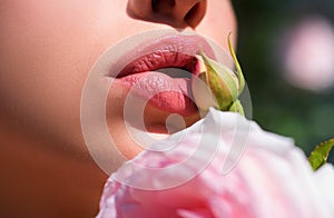 Sexy Lips. Beauty Red Lips Makeup Detail. Lips with spring flowers closeup. Beautiful woman lips with rose.