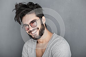 man with beard smiling big against wall photo