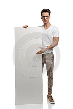 sexy man with glasses showing and presenting white empty board