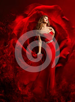 Sexy Model in Red Dress dancing over Fantasy Rose Background. Beauty Woman Art Portrait. Luxury Fashion Model in Evening Gown
