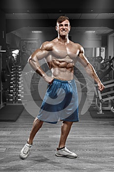 muscular man posing in gym, shaped abdominal. Strong male naked torso abs, working out