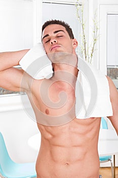 naked muscular man with white towel drying hair