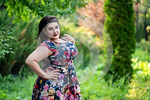 Sexy plus size fashion model in floral dress outdoors, beautiful fat woman with beauty makeup and hairstyle