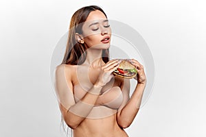 Sexy pretty girl in stylish bra enjoying eating fast food