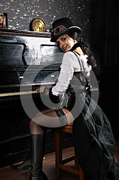 Sexy pretty steampunk girl playing the piano photo