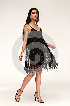 Sexy pretty woman tanned skin long brunette dark hair bright makeup wear fashion party style sequins little black dress for