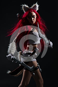 Sexy redhead woman in cosplay costume of warrior cat with swords
