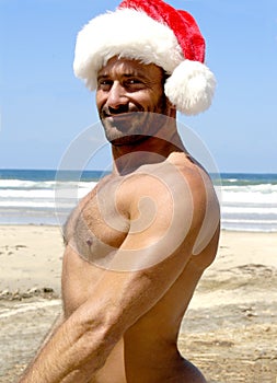 Sexy Santa at the beach giving an awesome smile.