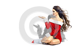 santa. Christmas beauty girl pointing hand. Brunette young woman wearing short red dress