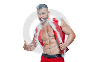 Sexy Santa Claus. Bodybuilder young handsome santa clause smile shows off abs cubes at New Years eve and Christmas