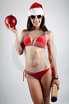 santa girl in bikini holding a Christmas ball