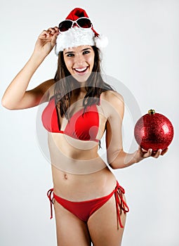 santa girl in bikini holding a Christmas ball