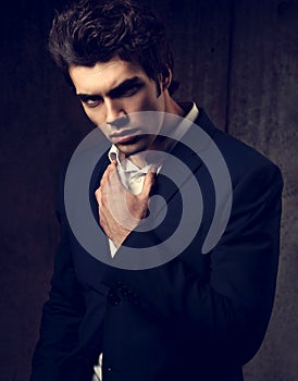 serious handsome male model posing in blue fashion suit and
