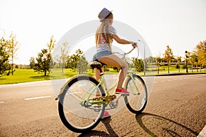 Sexy shapely girl with hat and mini shorts ride a bicycle photo
