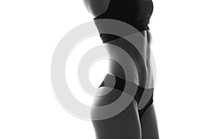 Sexy slim fit woman body with dumbbells. Muscled abdomen. Sportswear. Isolated on white. Black and white image