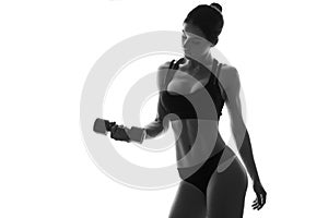 Sexy slim fit woman body with dumbbells. Muscled abdomen. Sportswear. Isolated on white. Black and white image
