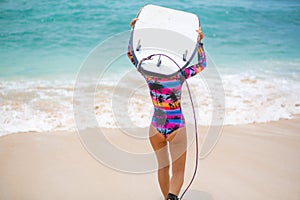 Sexy slim girl with surf board on tropical sand beach. Healthy active lifestyle in summer vocation